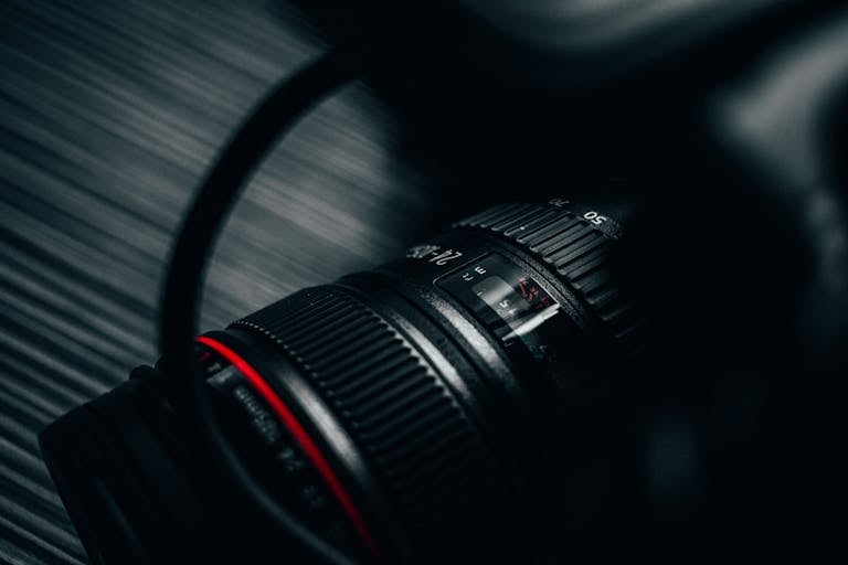 Detailed close-up view of a DSLR camera lens with subtle highlights, showcasing precision design.